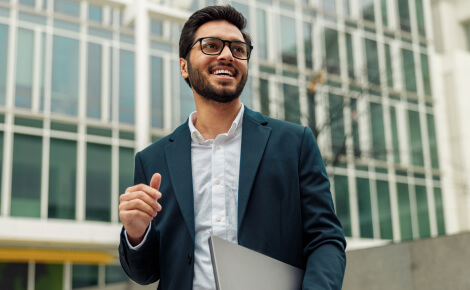 Man in a suit holding a laptop